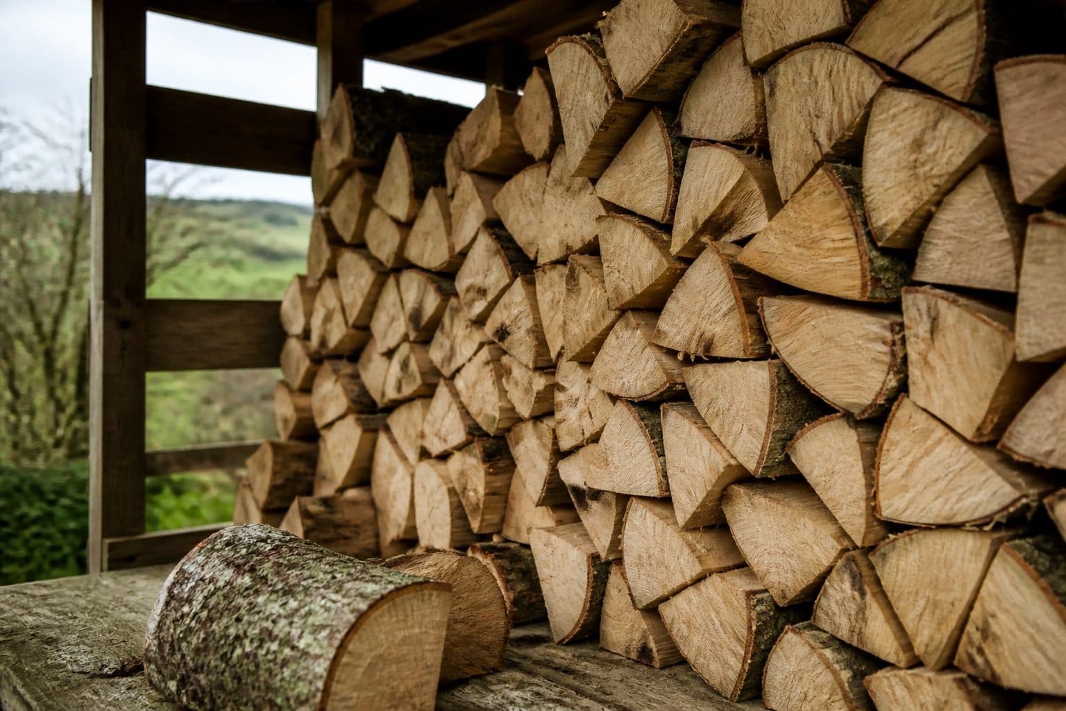 Stacked kiln dried hardwood logs showing dry, seasoned cut ends